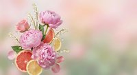 Elegant floral arrangement with pink peonies, roses and citrus slices on soft pastel background for spring wedding invitations and romantic greeting cards.