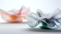 Ethereal flowing fabric in soft pastel colors creates abstract waves and curves against white background, showcasing delicate translucent material in motion.