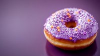Fresh baked donut with vibrant purple frosting and colorful sprinkles on dark reflective surface against purple background, macro food photography.