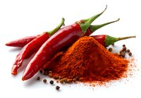 Fresh red chili peppers with heap of ground paprika powder and black peppercorns on white background, ideal for cooking and spicy cuisine.