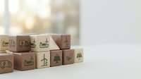 Wooden blocks with green eco-friendly icons including renewable energy, recycling, and sustainability symbols arranged on white surface with copy space.