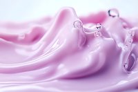 Smooth pink cosmetic cream texture with water droplets in macro photography. Luxurious skincare product background showing silky moisturizer surface detail.