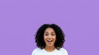 Young woman with curly black hair and medium brown skin tone wearing white shirt against vibrant purple background, expressing surprise or excitement for portrait and lifestyle content.