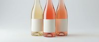Three wine bottles with blank white labels on neutral background, mockup template for branding and packaging design projects.