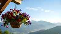 Hanging flower basket with colorful petunias on wooden pergola overlooking mountain landscape. Perfect for garden decor and outdoor living concepts.