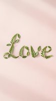 Love word made from green leaves on soft pink background for romantic wedding invitations and Valentine's Day greeting cards.