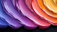 Vibrant gradient paint strokes in rainbow colors from purple to orange, flowing in smooth waves. Abstract artistic background for creative projects.