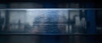 Abstract metallic surface with horizontal brushed texture and blue lighting effects creating industrial modern background for design projects.