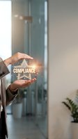 Business professional hands protecting glowing compliance star symbol with digital effects in modern office environment for corporate governance concepts.