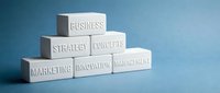 White wooden blocks arranged in pyramid formation displaying business terminology on blue background for corporate presentations and strategic planning.