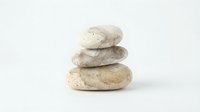 Stacked smooth river stones isolated on white background, suitable for wellness, spa, and meditation design projects.