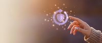 Unrecognizable person holding glowing heart shield icon with sparkling light effects, symbolizing healthcare, protection, and digital wellness technology.