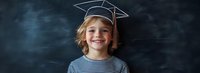 Young student wearing striped shirt and drawn graduation cap smiling against dark chalkboard background, representing education and academic achievement.