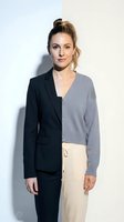 Professional Caucasian businesswoman in split formal and casual outfit representing work-life balance concept against neutral studio background.