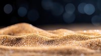 Golden glittering sand dunes with soft bokeh background in macro photography, creating abstract landscape with shimmering particles and dreamy atmosphere.