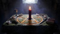 Mystical altar with burning candle in pentagram circle surrounded by crystals and ritual items in dark stone chamber with dramatic lighting.