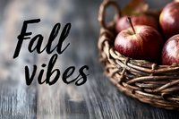 Fresh red apples in rustic wicker basket on wooden table with fall vibes text overlay, perfect for seasonal harvest marketing and autumn social media content.