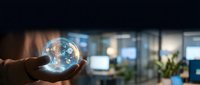 Businessman holding glowing digital globe with network connections in modern office environment showcasing global business technology and connectivity.