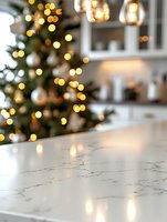 Marble kitchen counter with blurred Christmas tree and bokeh lights in background, modern festive home interior with white shelving and warm holiday glow.