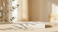 Cylindrical white marble podium with shadow patterns on neutral beige background, eucalyptus branch beside it. Product display stand for cosmetics, skincare, jewelry, and luxury goods.