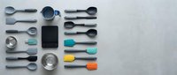 Modern kitchen utensils and cookware arranged in organized flat lay pattern on white background for culinary design projects and cooking concepts.
