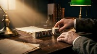 Man in business attire arranging wooden letter blocks spelling "ideas" on wooden desk with lamp and papers, representing creativity, brainstorming and business planning concepts.