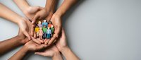 Diverse hands holding colorful paper figures together, symbolizing unity, teamwork, community support, and inclusive collaboration for nonprofit and social cause campaigns.