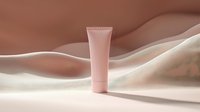 Pink cosmetic tube on wavy beige silk background with soft shadows, minimal luxury skincare product presentation for beauty and wellness marketing.