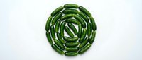 Fresh green cucumbers arranged in a circular spiral pattern on white background, isolated for food design, culinary projects, and healthy eating concepts.