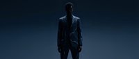 Man in dark leather jacket standing against blue background, suitable for corporate, fashion, and lifestyle design projects.
