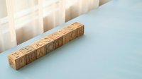 Business education spelled out in wooden letter blocks with stacked paper cubes creating professional learning environment for corporate training concepts.
