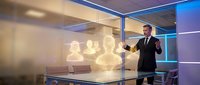 Professional businessman presenting holographic data visualization in modern glass conference room with futuristic technology interface.