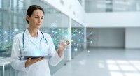 Female doctor in white coat with stethoscope using digital tablet with holographic medical network icons in modern hospital corridor for healthcare technology.