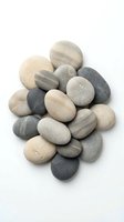 Collection of smooth river stones in natural earth tones isolated on white background for spa wellness meditation and zen design projects.