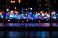 Glowing blue and orange bokeh lights create magical atmosphere with sparkles on reflective surface, defocused background for festive designs and holiday projects.