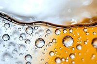 Abstract macro photography of water drops and liquid waves creating dynamic pattern with orange and white gradient background for modern design.