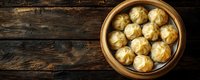 Asian steamed dumplings in traditional bamboo steamer on dark wooden background with copy space, top view of homemade dim sum.