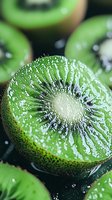 Fresh sliced kiwi fruit with water drops in macro view showing detailed texture and juicy flesh, vibrant green color and tiny black seeds on dark background.