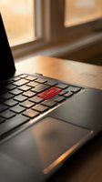 Laptop keyboard with red order button highlighted in warm sunlight for e-commerce and online shopping concepts.