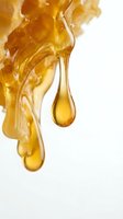 Golden honey dripping from honeycomb with crystallized texture on white background. Isolated design element suitable for food packaging, culinary websites, and wellness product marketing.