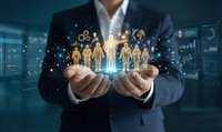 Professional businessman holding glowing digital human icons representing team management and HR technology in modern office environment.