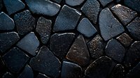Dark stone mosaic wall with irregular shaped pieces creating dramatic texture and pattern. Natural rock surface with rough edges and varied tones for architectural design.