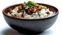 Savory braised meat with herbs served over fluffy white rice in ceramic bowl, comfort food meal ready to eat for restaurant menu or home cooking.