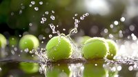 Tennis balls splashing into water creating dynamic droplets and ripples against blurred green background. Fresh sports concept.