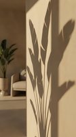 Tropical plant shadow cast on a beige wall in a minimal interior, warm sunlight creating a natural botanical silhouette for home decor concepts.