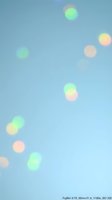 Soft pastel bokeh lights floating on dreamy blue gradient background creating ethereal atmosphere for creative projects and digital designs.