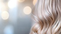Luxurious platinum blonde wavy hair close-up with soft bokeh background. Gentle waves and highlights create elegant texture for beauty and haircare advertising.