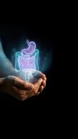 Hands holding glowing holographic digestive system with stomach and intestines on dark background for medical education and healthcare concepts.