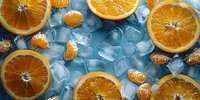Fresh orange slices and peeled mandarin segments scattered on ice cubes background, bright citrus fruit composition in cool blue tones for refreshing drinks.