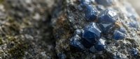 Blue fluorite crystal formation embedded in natural rock matrix with geometric cubic structures and metallic luster for geology education and mineral collection.